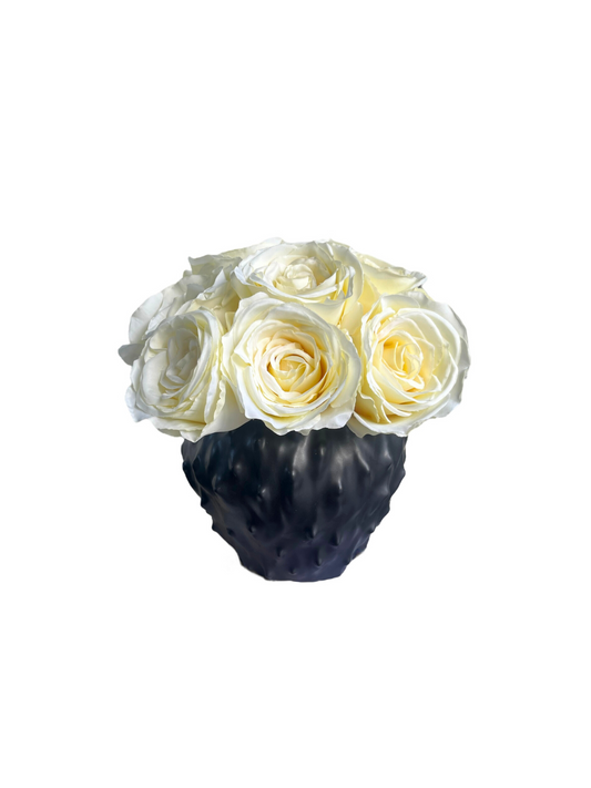 soft cream artificial roses set in a contemporary black vase.
