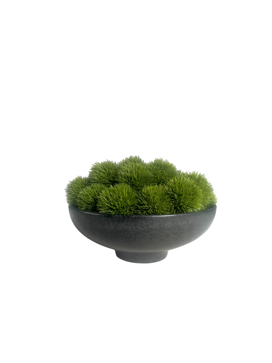 Lush green artificial dianthus set in a footed black ceramic bowl.