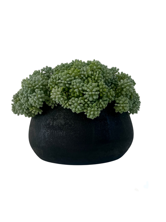 Muted green artificial sedum set in a black melange terracotta bowl planter.
