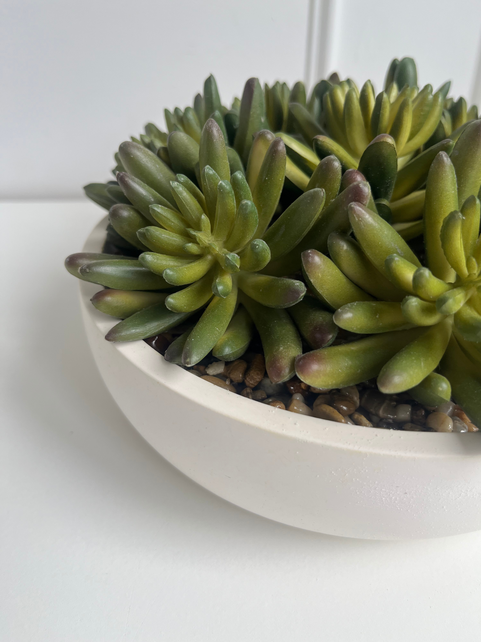 lush green artificial agave succulents set in stones in a cream colour eco resin bowl.